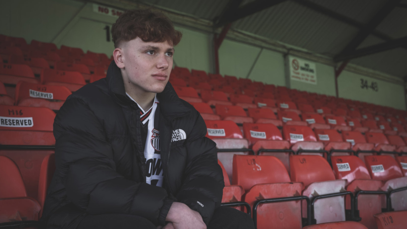 Alfie Artist sat in the stand at blundell park