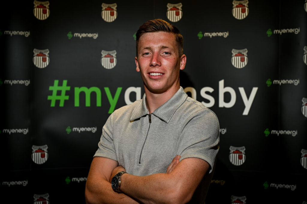 Harry Clifton stood in front of sponsor board