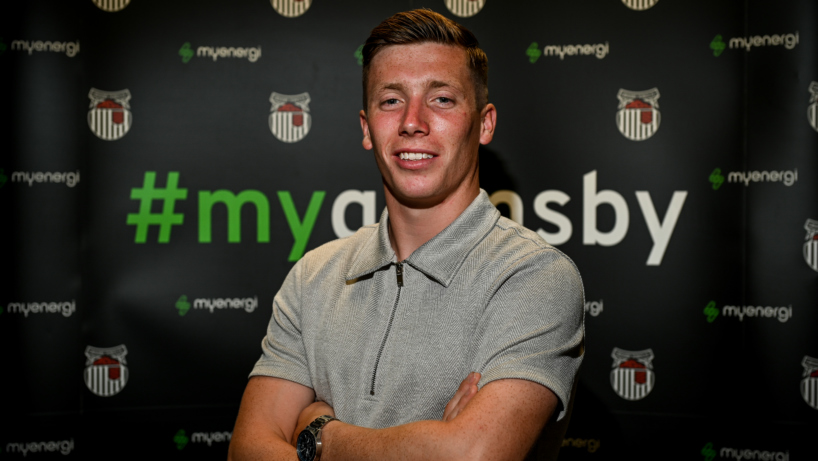Harry Clifton stood in front of sponsor board