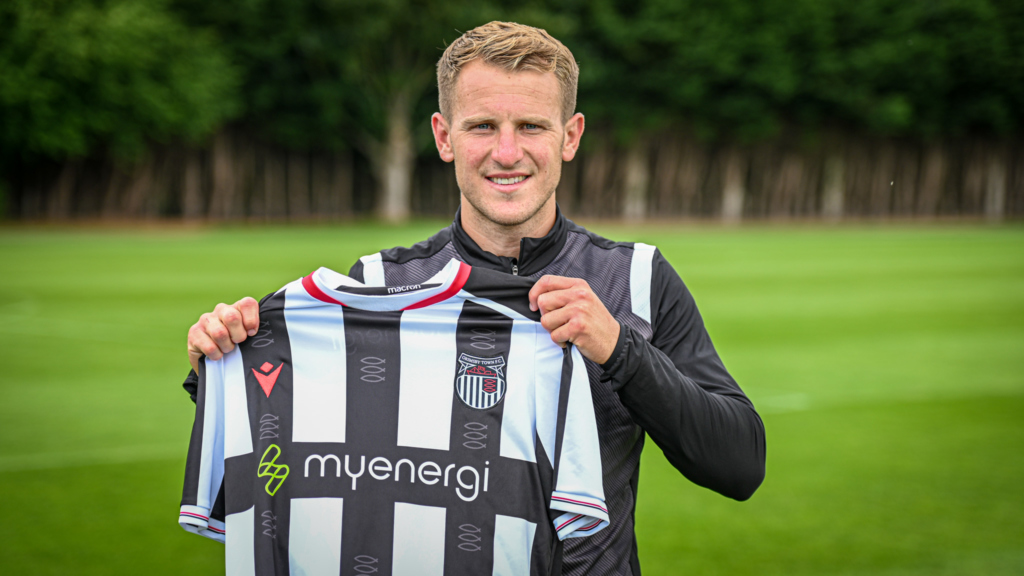 Bryn Morris holds a new GTFC shirt after signing his contract